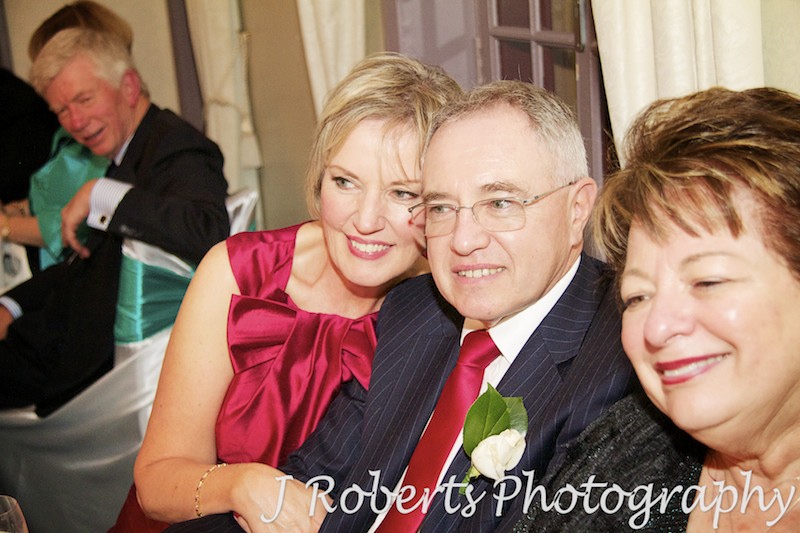 Grooms parents enjoying speeches at wedding reception - wedding photography sydney